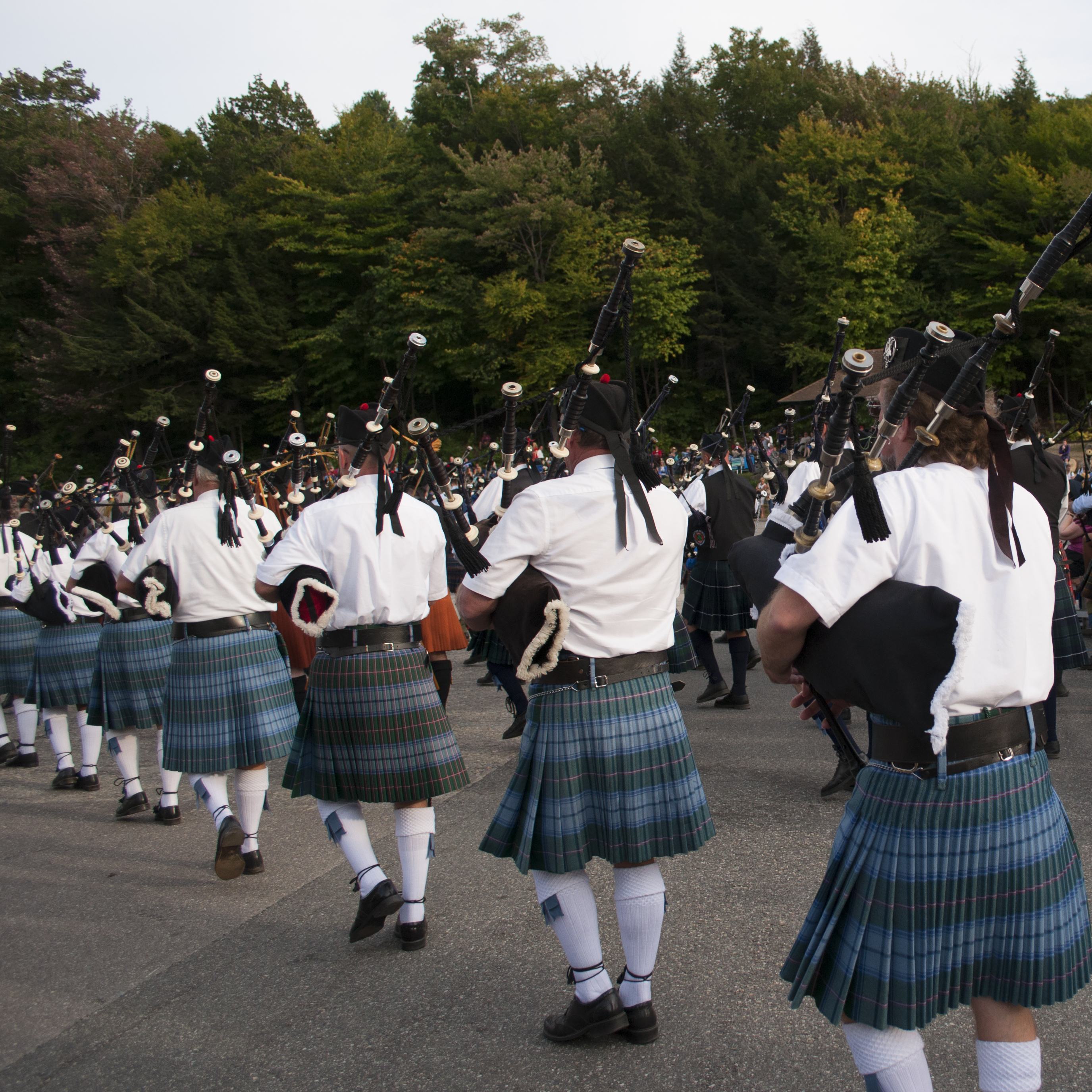 hundreds of scottish bagpipers marching in unison at highland games