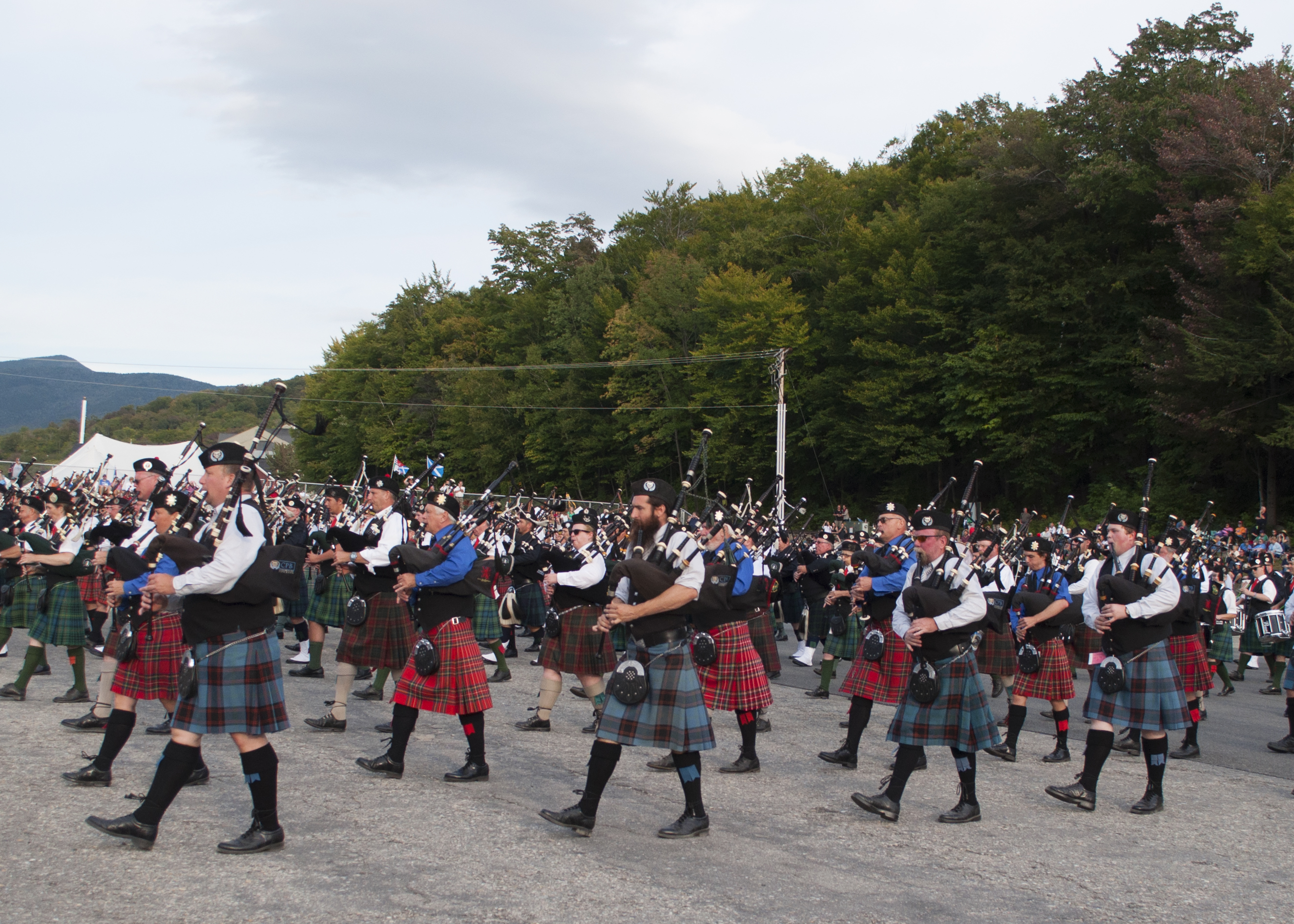 hundreds of scottish bagpipers marching in unison at scottish highland games