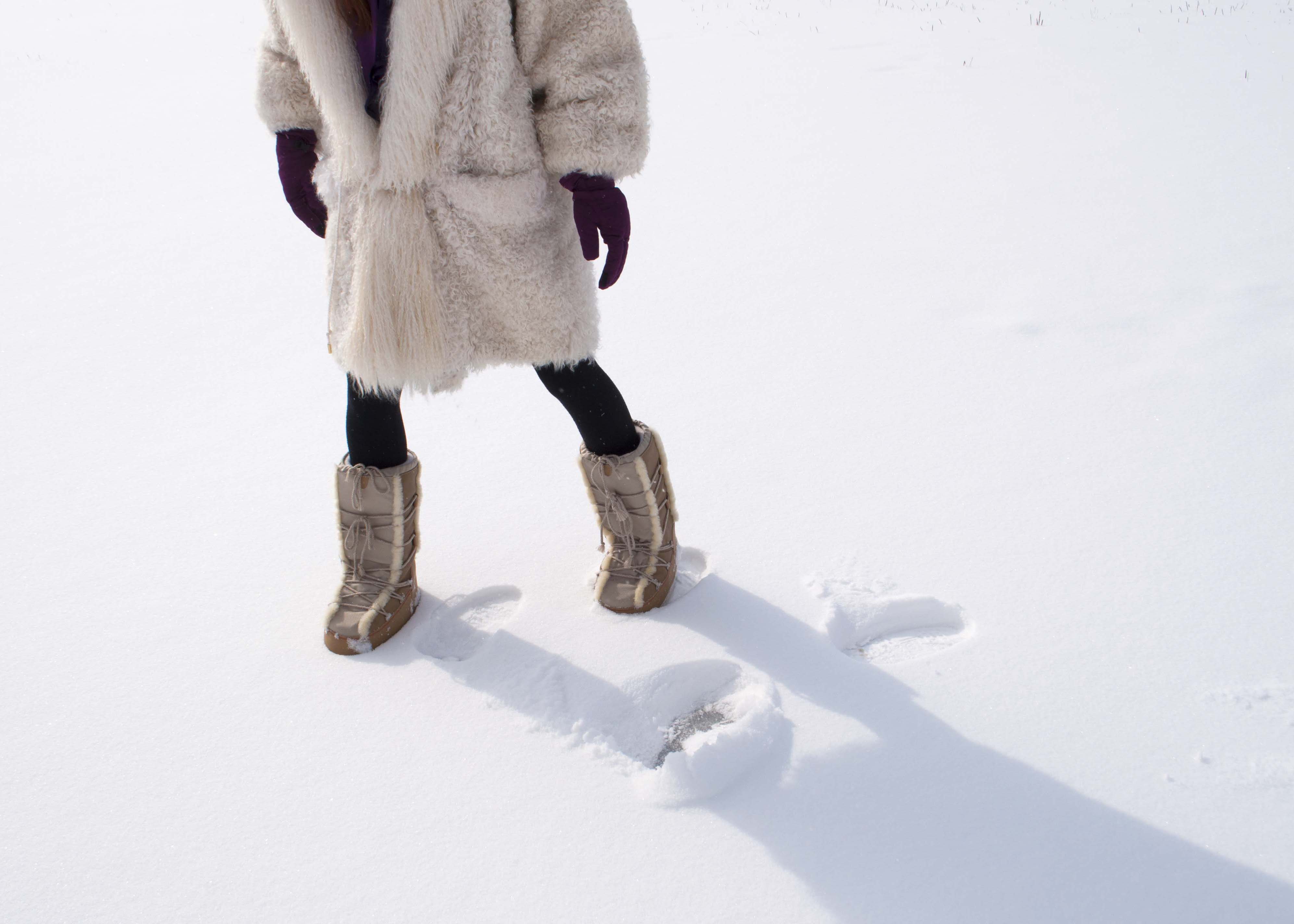 fur coat and moon boots on fresh snow